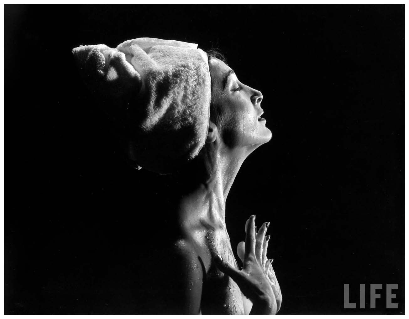 woman-w-head-wrapped-in-towel-appears-to-be-standing-under-shower-smoothing-water-over-skin-with-hands-1946-gjon-mili.jpeg